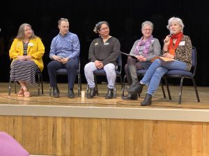 Photo of the Skagit County Library Directors and Acting Directors sitting in chairs on an auditorium stage.