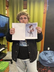 A teen showing his drawing.